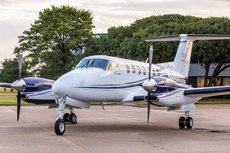 Imagem de um turbo-hélice Beechcraft King Air 360 branco parado em solo.